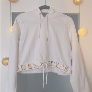 Cropped white hoodie with rose gold  brand name across bottom. Adjustable string